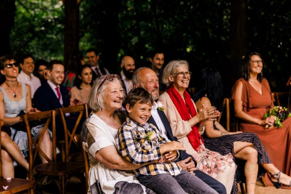 little boy sits on womans lap laughing