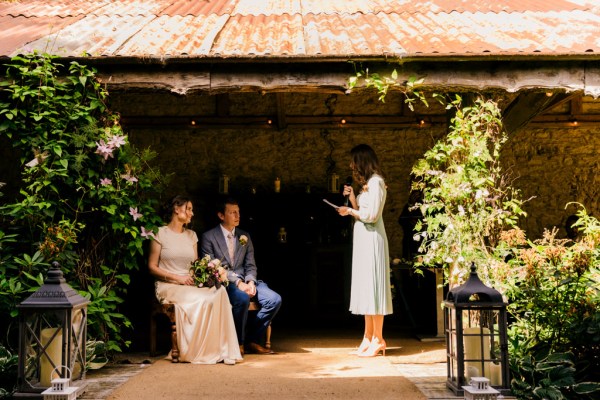 celebrant gives speech while bride and groom are seated