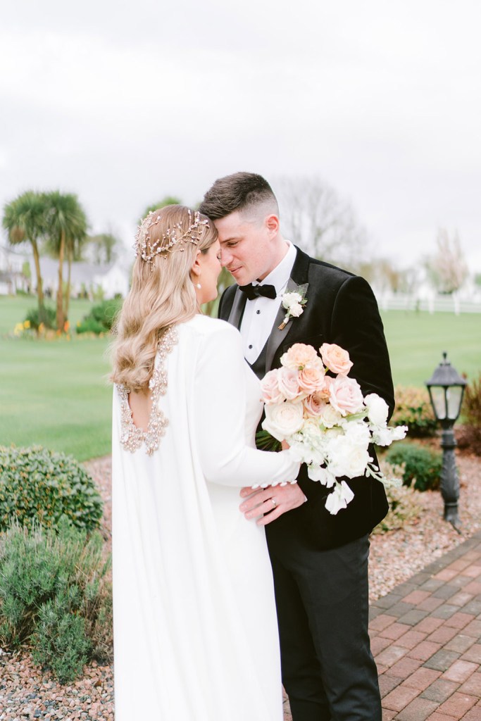 bride and groom close touching foreheads she holds bouquet in hand