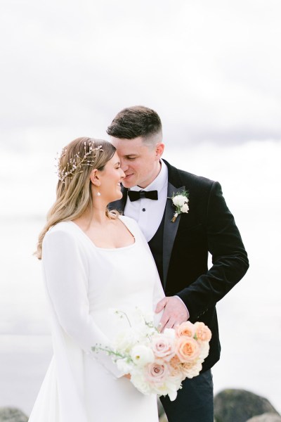 bride and groom hold each other closely she holds bouquet in hand