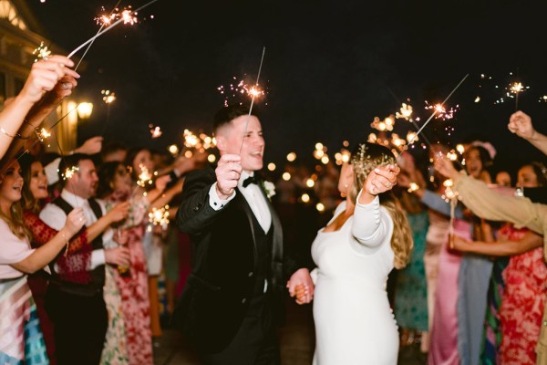 bride and groom on the dancefloor surrounded by guests lights in the background