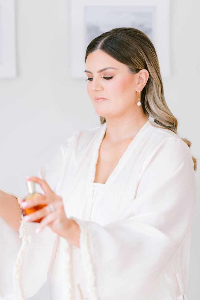 bride sprays perfume on to wrist