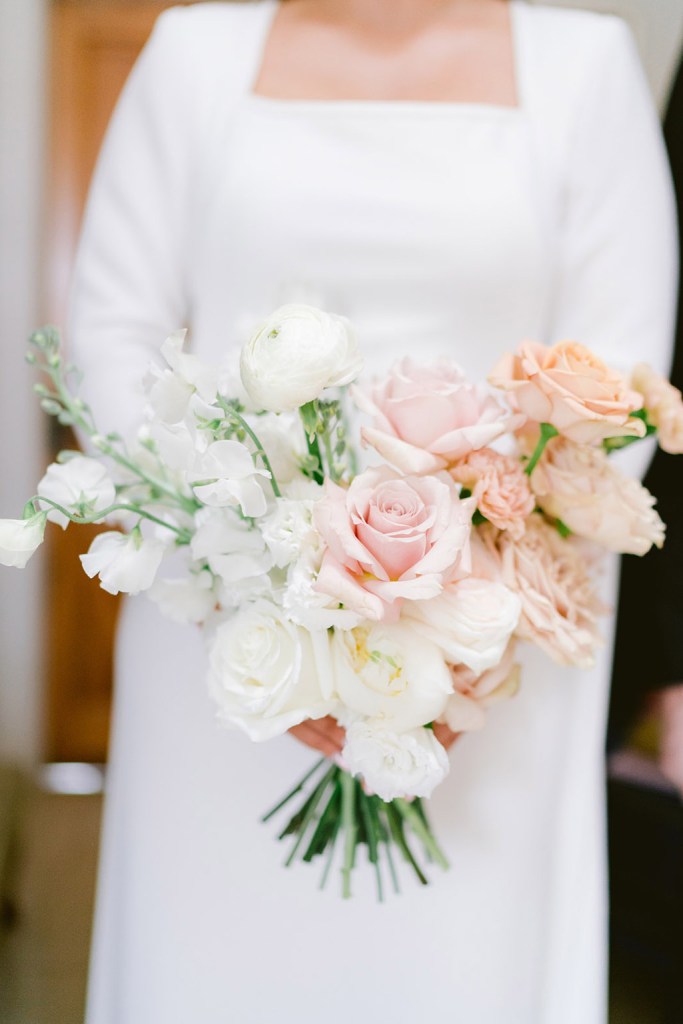 bride holds up bouquet roses flowers in hand