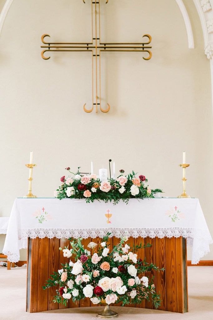 alter setting laid out cross on wall and flowers on top