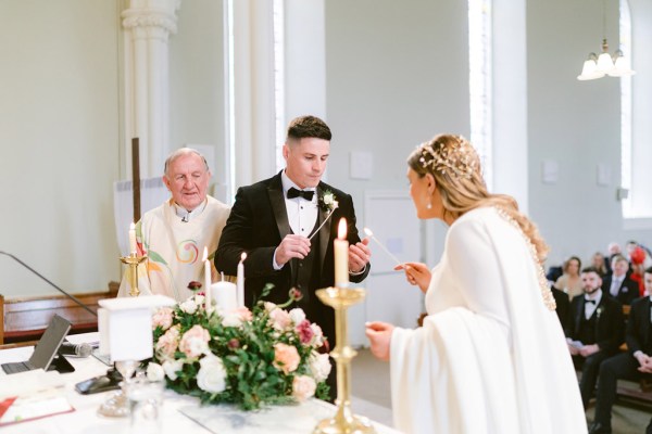 bride and groom light candles together at the alter