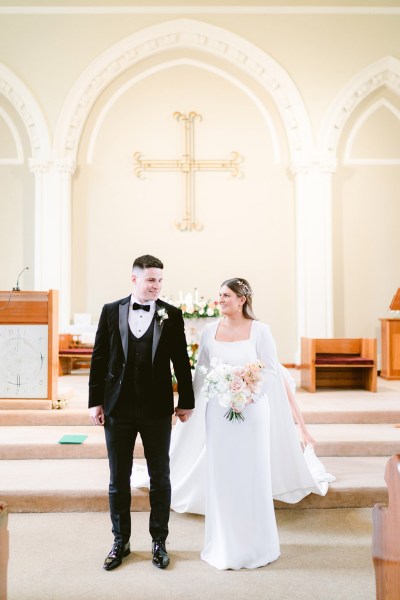 bride and groom stand at top of alter just wed