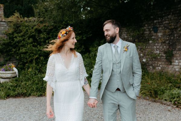 bride and groom holding hands looking at each other