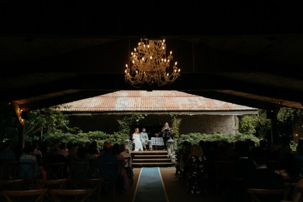 wide shot hut bride groom with celebrant at alter