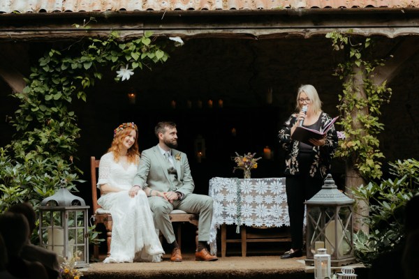 bride groom and celebrant at alter setting speaking into microphone