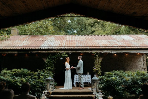 bride and groom stand at alter setting ceremony steps holding hands