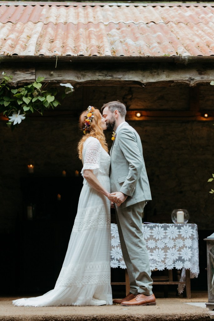 bride and groom kiss at the alter during wedding ceremony