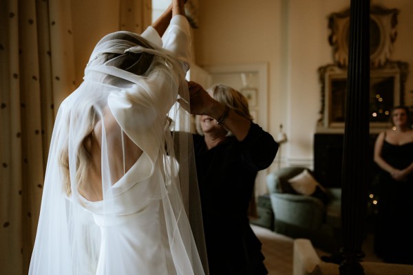 mother helps daughter with veil