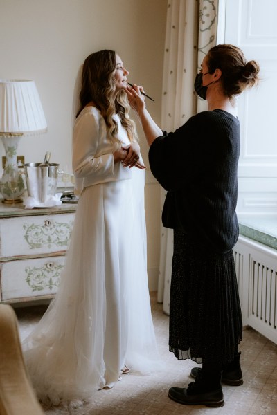 bride getting her makeup done MUA at window