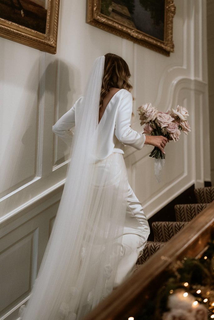 bride walking up the steps holding bouquet