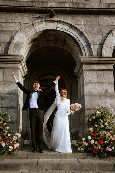 bride and groom hands in the air exit church ceremony