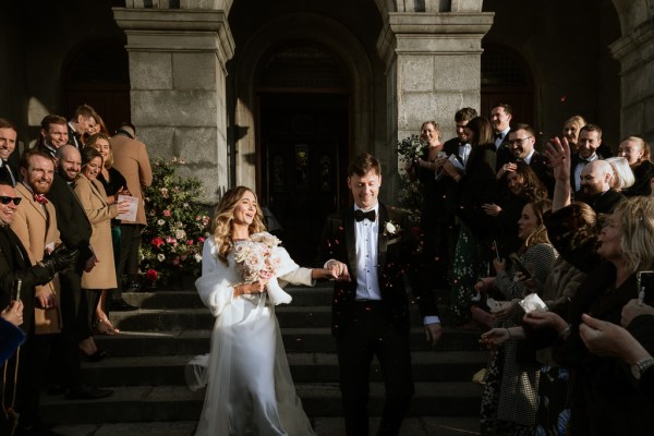 bride and groom exit ceremony guests clap they walk down steps