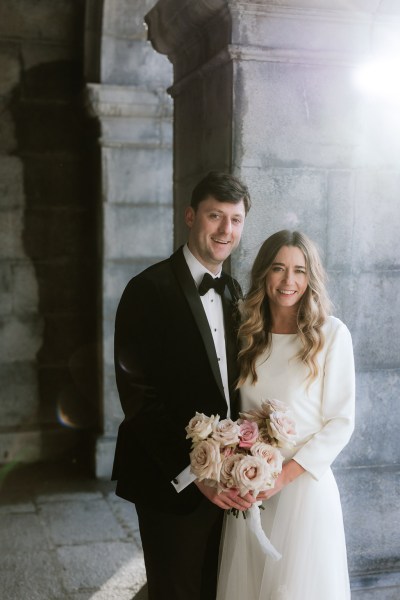 bride and groom close she holds bouquet of white flowers