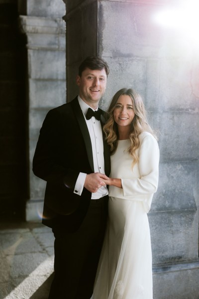 bride and groom hold hands smiling