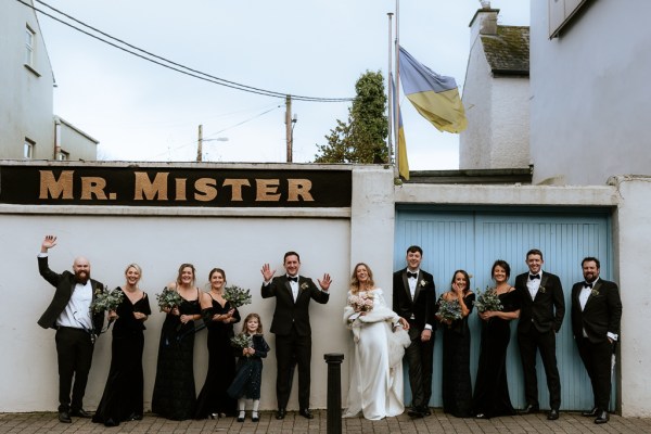 Mr. Mister sign bride groom groomsmen and bridesmaids all have bouquet in the air celebrating