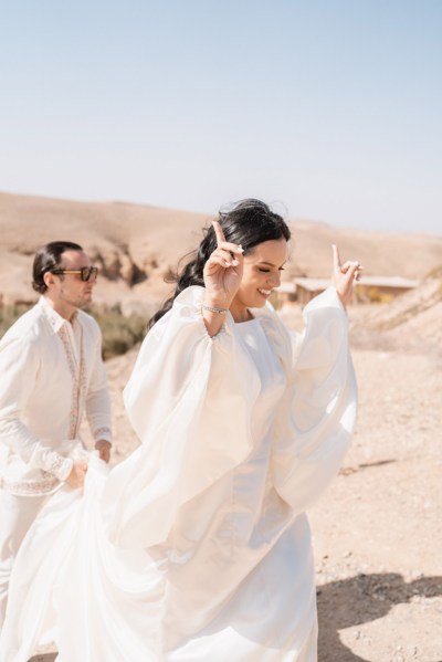 bride and groom celebrate on the sand