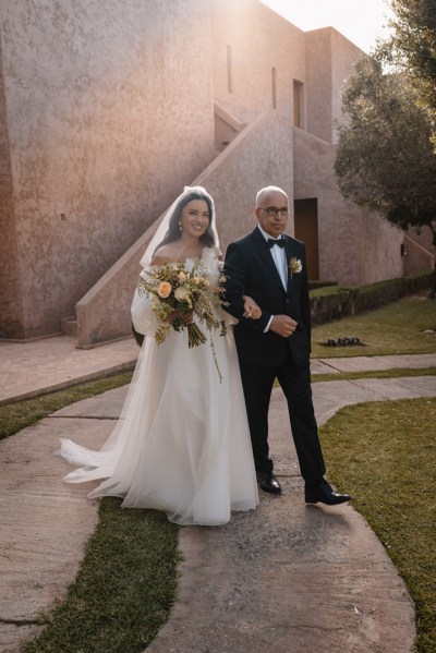 father of the bride walks his daughter towards ceremony