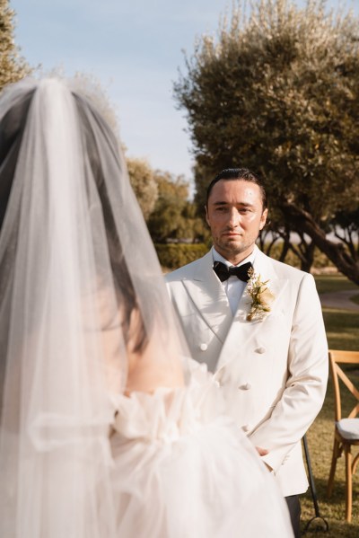 groom faces bride at alter