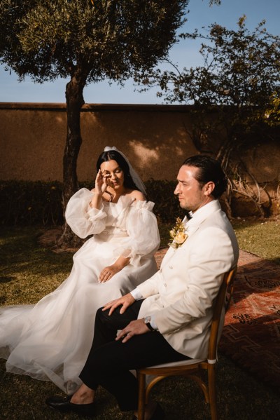 emotional bride sits with groom at alter