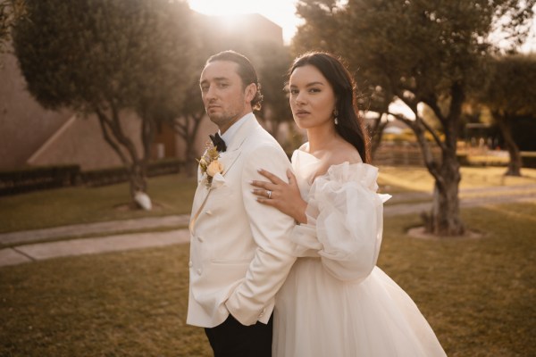 bride and groom walk on the grass together