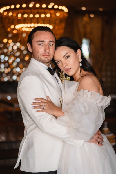 bride and groom pose for a photo holding each other interior