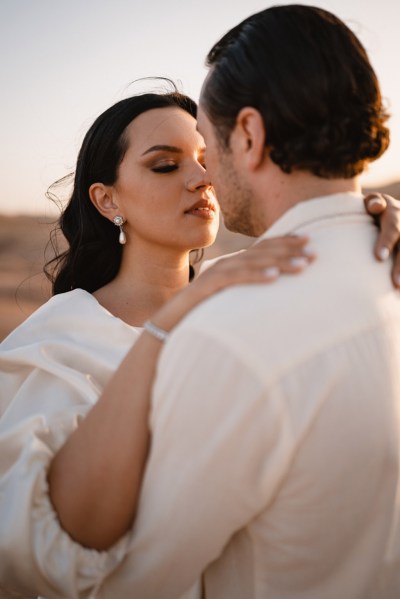 bride holds grooms shoulders