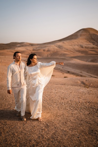 bride and groom in the wind desert setting sand