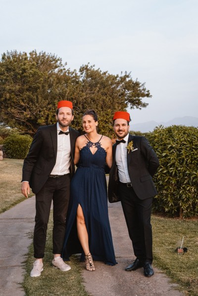 guests pose two men one woman outside in garden