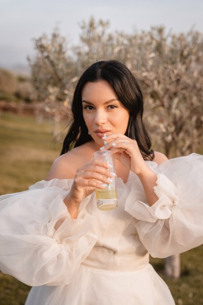 bride drinks from cocktail bottle sips out of straw