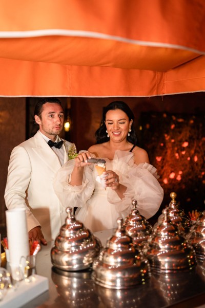 bride and groom preparing the cake