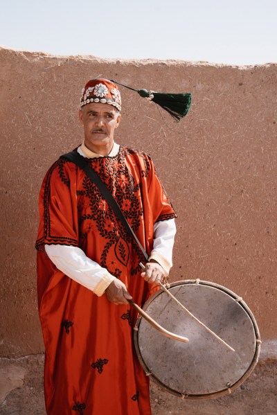 man in traditional cloth playing drums