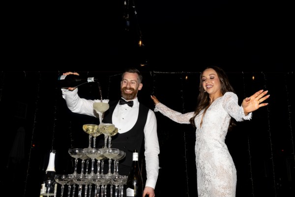 bride and groom pour champagne over the champagne fountain