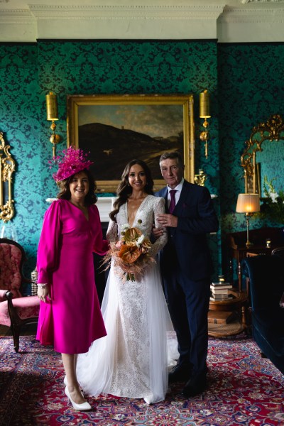 mother wearing pink bride and father pose for a photo