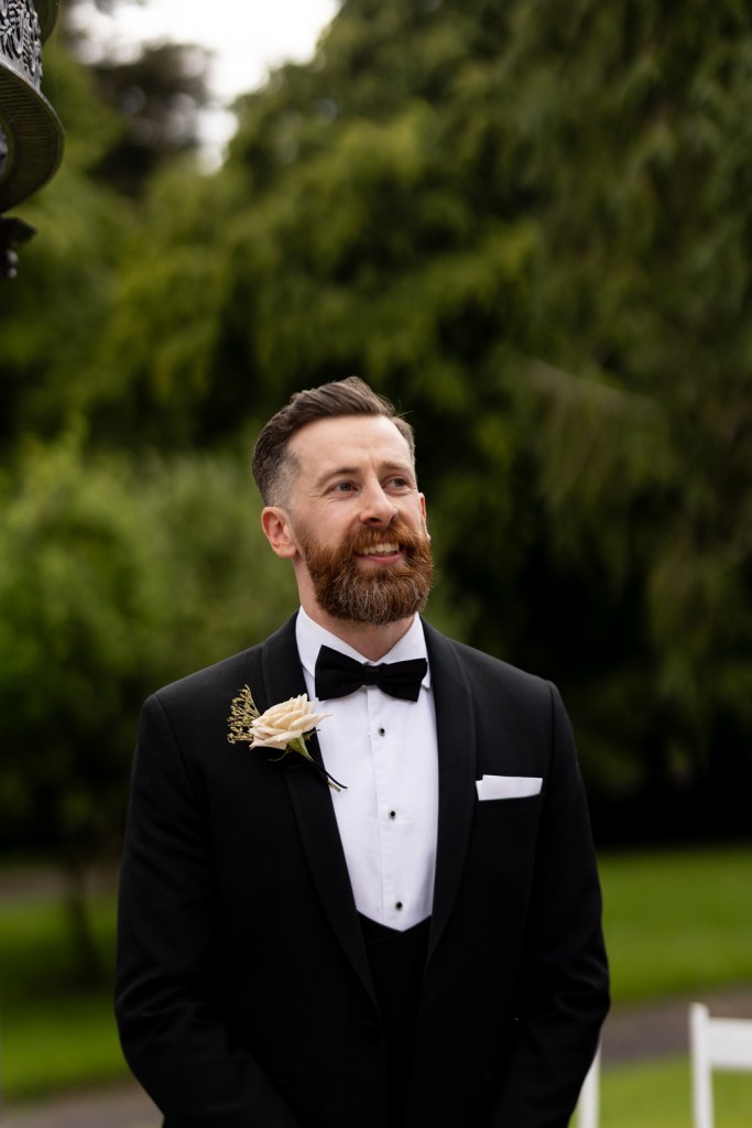 groom awaits his bride at the alter