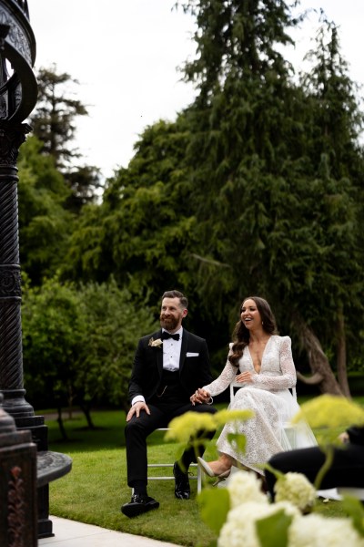 bride and groom hand holding sitting during ceremony