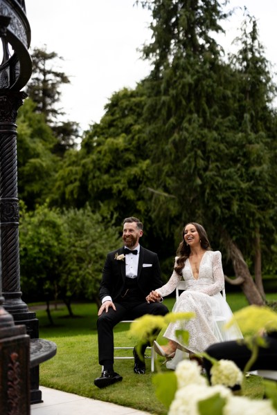 bride and groom hand holding sitting during ceremony