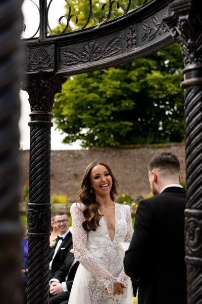 bride and groom smile at the alter