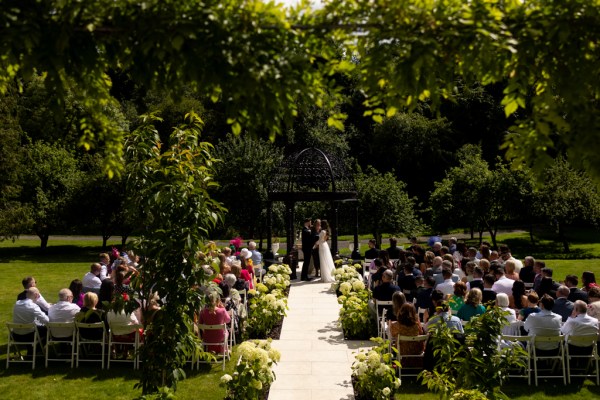 bride and groom at the alter as guests watch