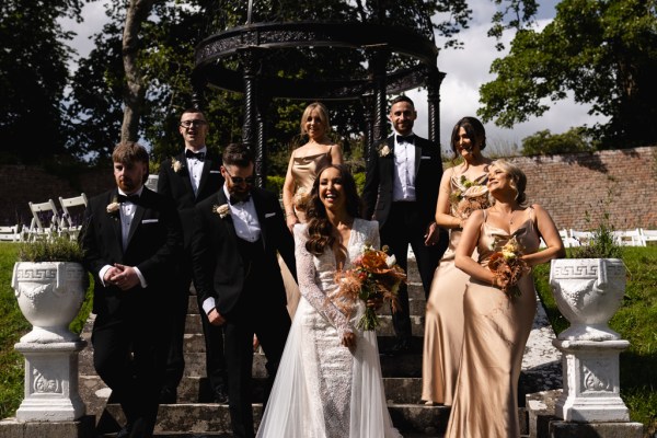 bride groom bridesmaids groomsmen pose for a photo on the steps