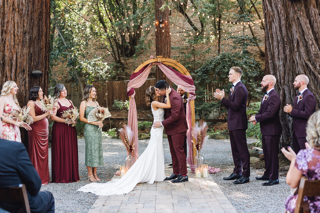 bride and groom kiss at the alter in front of guests