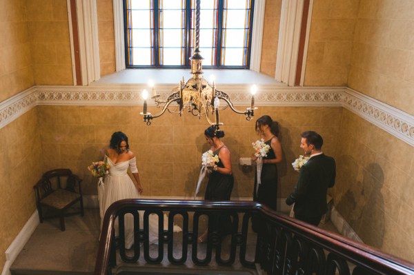 bride and bridesmaids walk down the staircase