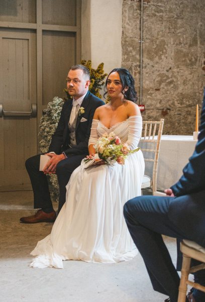 bride and groom sitting at alter