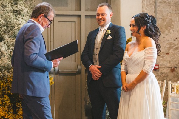 bride and groom at the alter with celebrant reading sermon