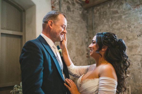 bride places hand on grooms face