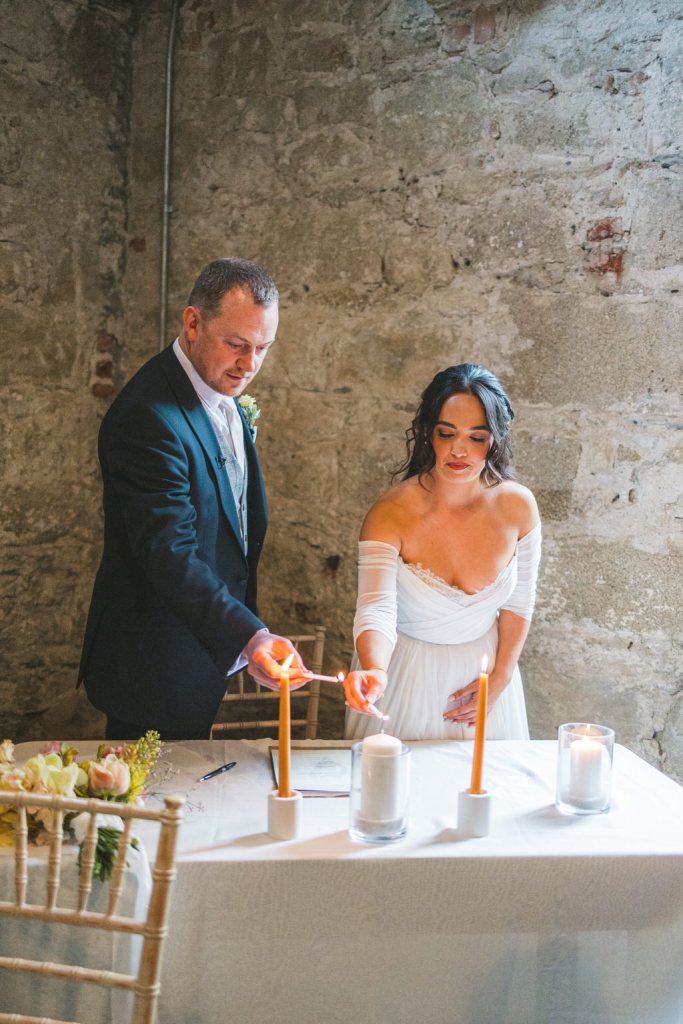 bride and groom light candles at alter table