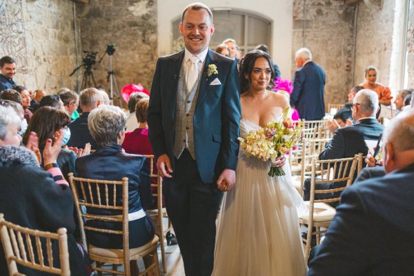 bride and groom are all smiles as they exit ceremony